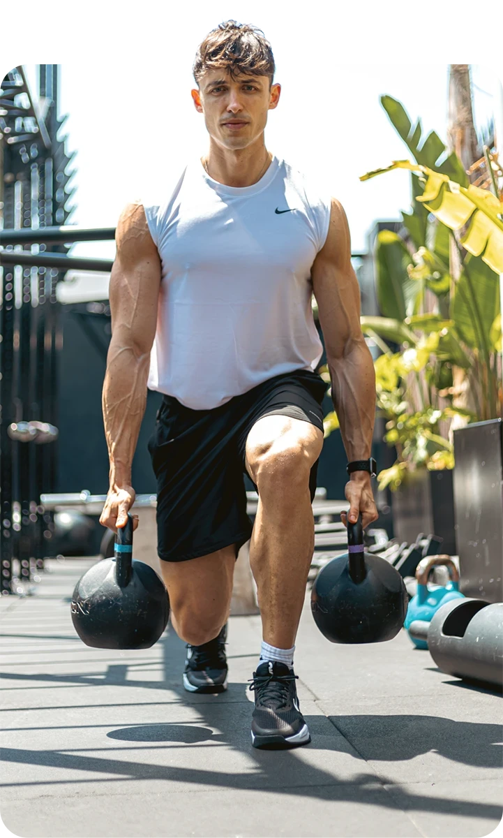 Nómada haciendo zancadas con dos kettlebells